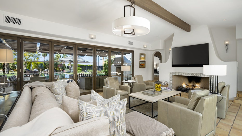 The living room features a wood-burning fireplace and access to the backyard.