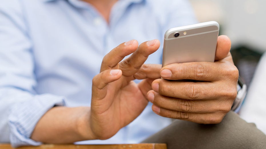 A businessman texts a cell phone