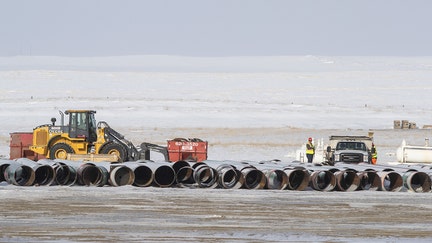 Workers load a truck with equipment at a pipe yard for the Keystone XL pipeline in Oyen, Alberta, Canada, on Tuesday, Jan. 26, 2021. U.S. President Joe Biden revoked the permit for TC Energy Corp.s Keystone XL energy pipeline via executive order hours after his inauguration, the clearest sign yet that constructing a major new pipeline in the U.S. has become an impossible task. Photographer: Jason Franson/Bloomberg via Getty Images